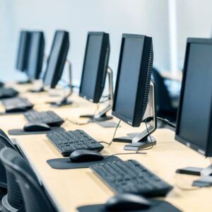 Row of computers on a desk at a workplace