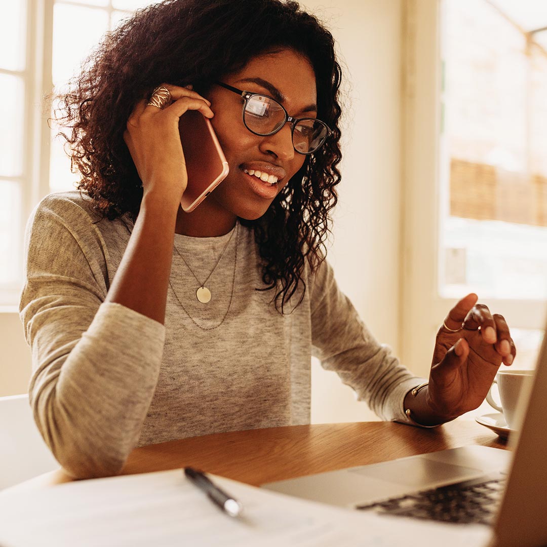 business woman on the phone while using a laptop