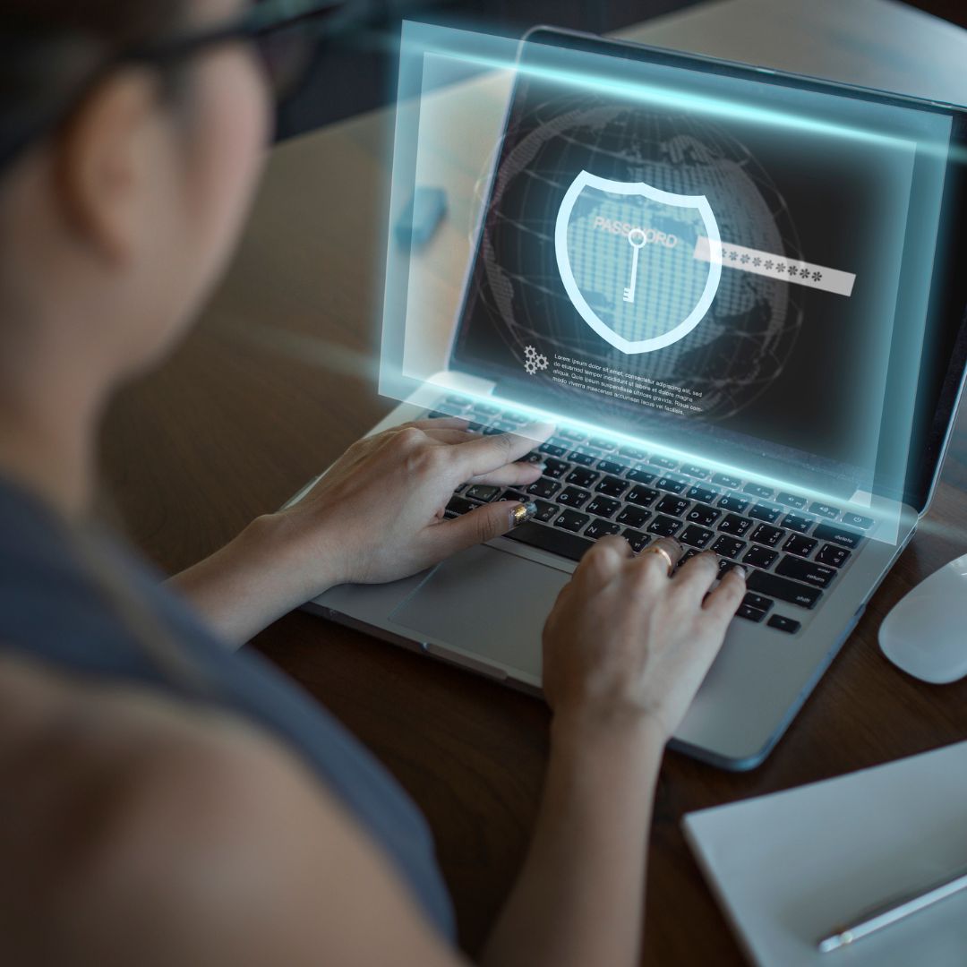 woman on computer with an icon of a shield overlaid